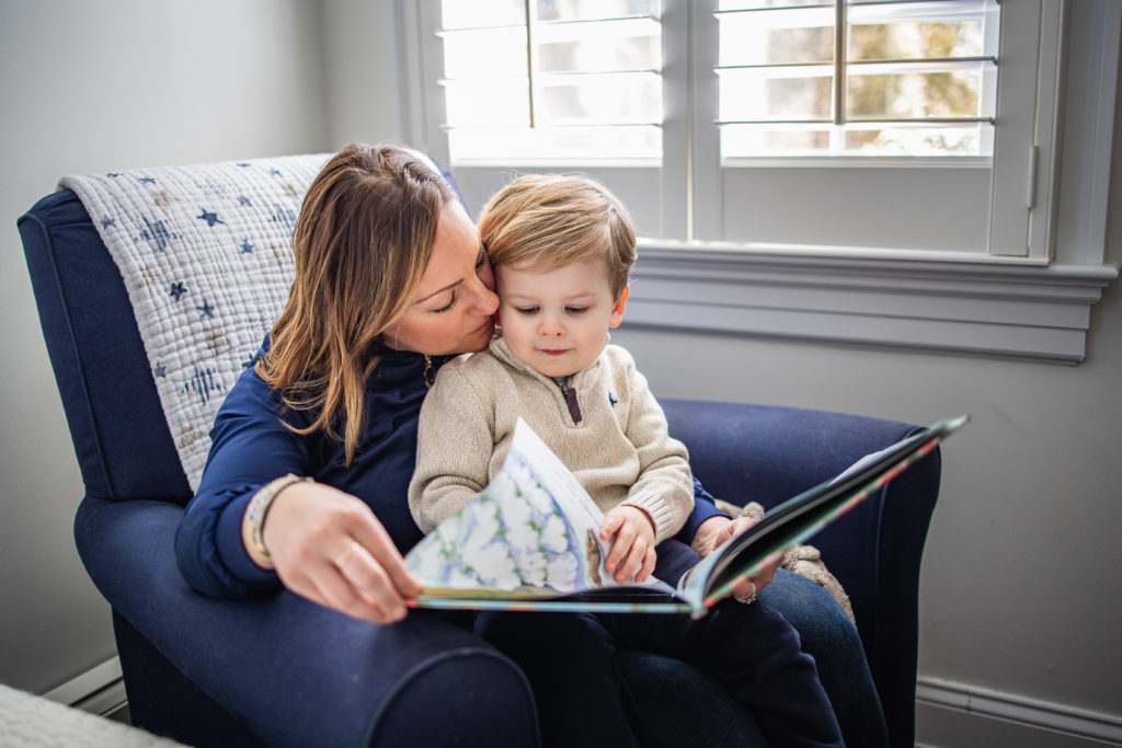 mom reading book to toddler during in home family session on long island