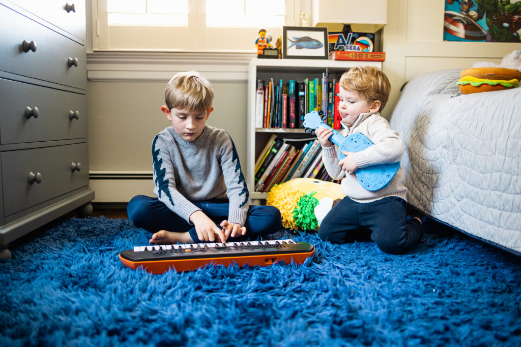 brothers playing in bedroom during in home family session